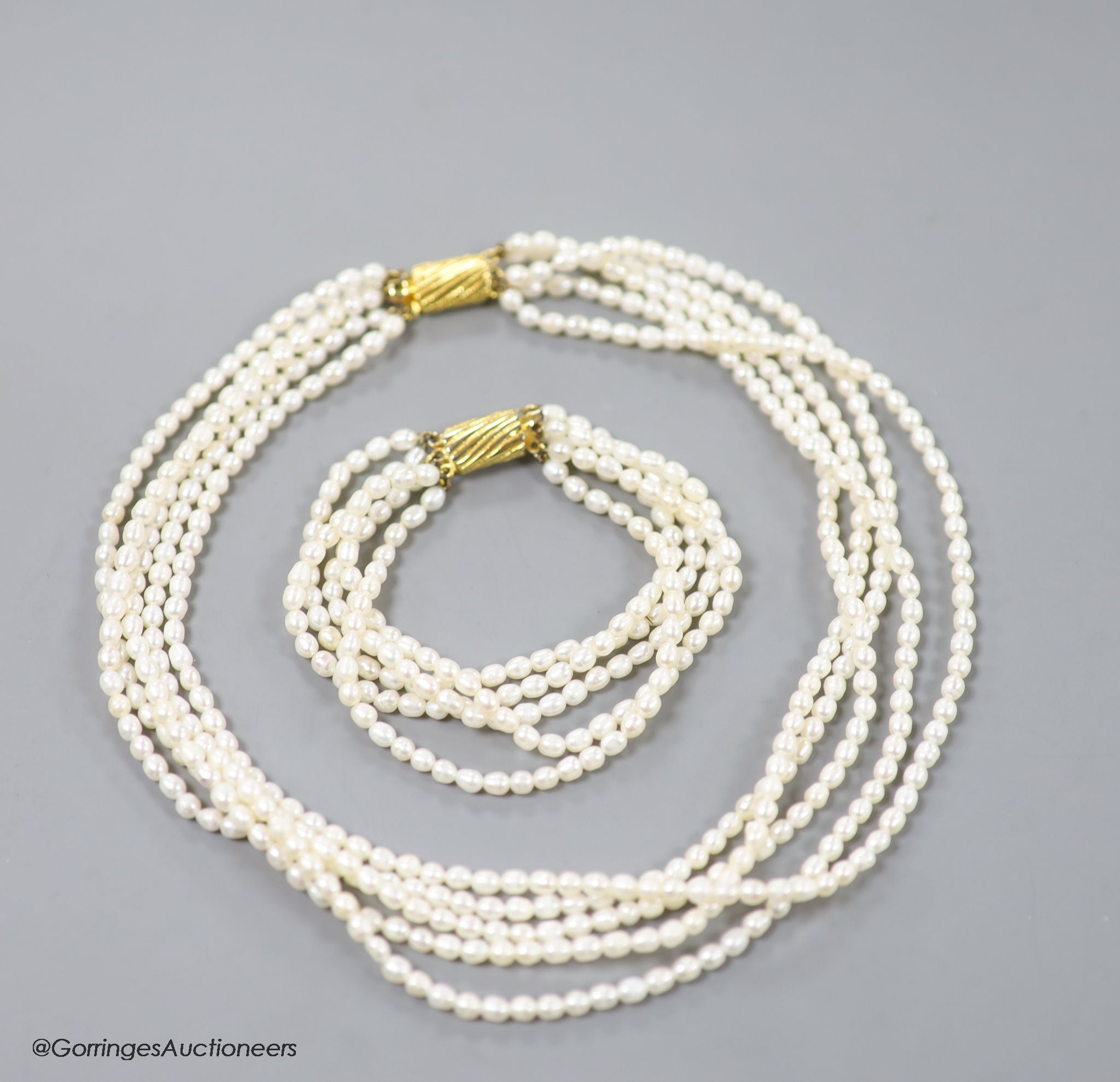 A modern multi strand cultured pearl necklace, with gilt metal clasp, 38cm and a matching bracelet, 17cm.